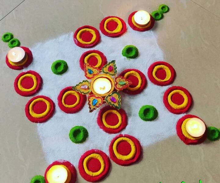 धनतेरस के मौके पर आप स्वास्तिक डिजाइन की रंगोली भी अपने घर के आंगन में बना सकते हैं. आप रेड कलर से डॉट बनाएं, इस चपटा करें और उसके ऊपर येलो कलर से रंग भरें. चारों कोनों पर दीपक लगाकर खूबसूरत और सिंपल रंगोली बनाएं.