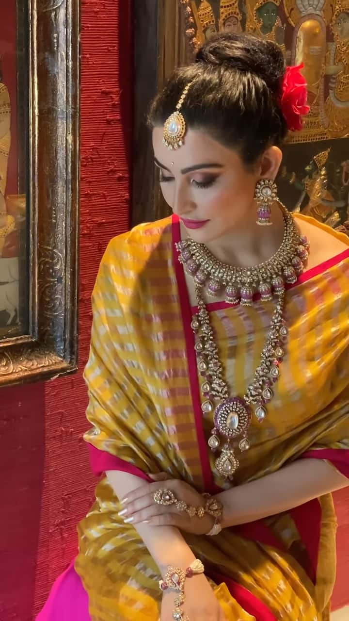 Shalini Passi’s luxurious golden Chanderi silk saree features a striking red Zardozi border and elegant golden striped Zari details.
