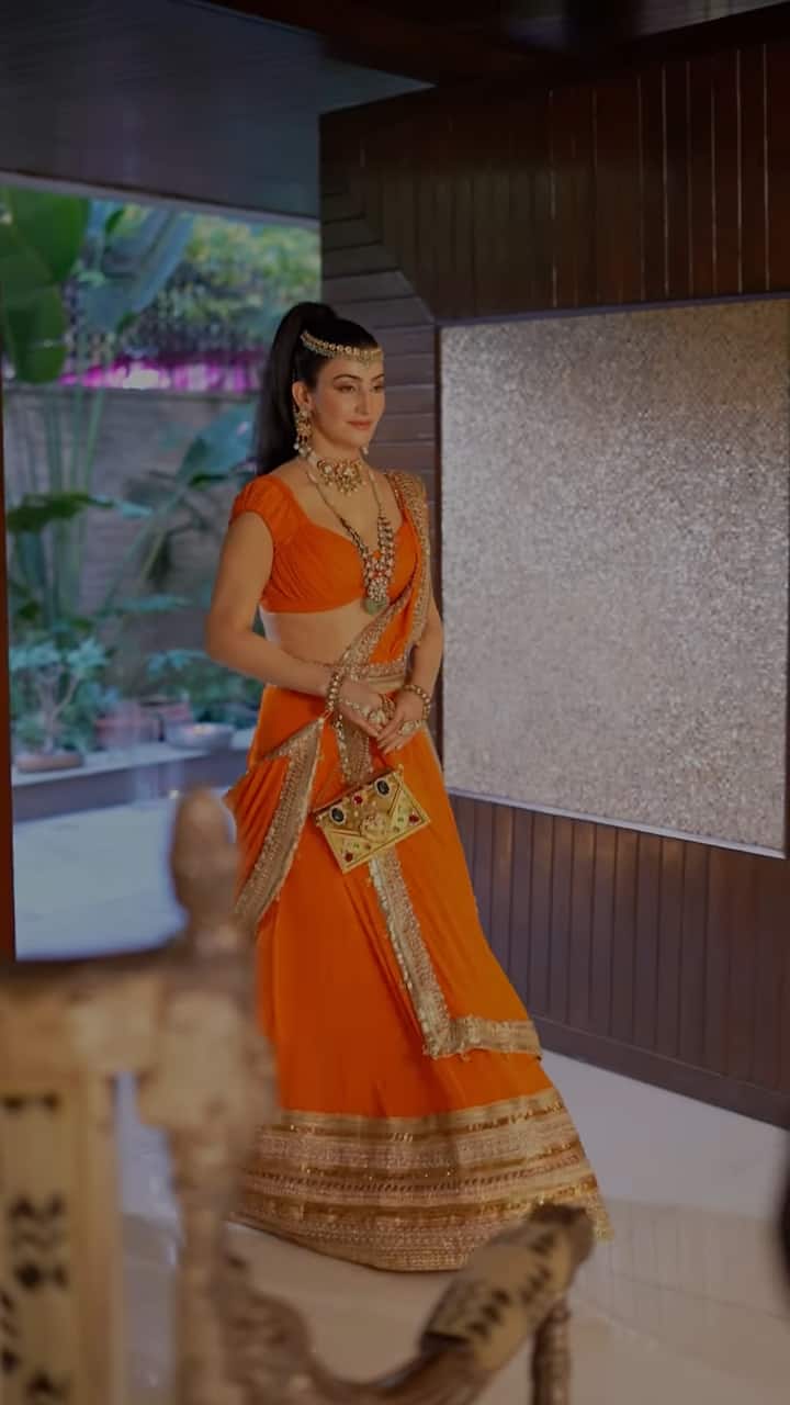 Shalini wore a orange lehenga saree from Fabulous Lives VS Bollywood Wives, featuring a rose gold sequin border, paired with a matching dupatta and emerald jewelry.