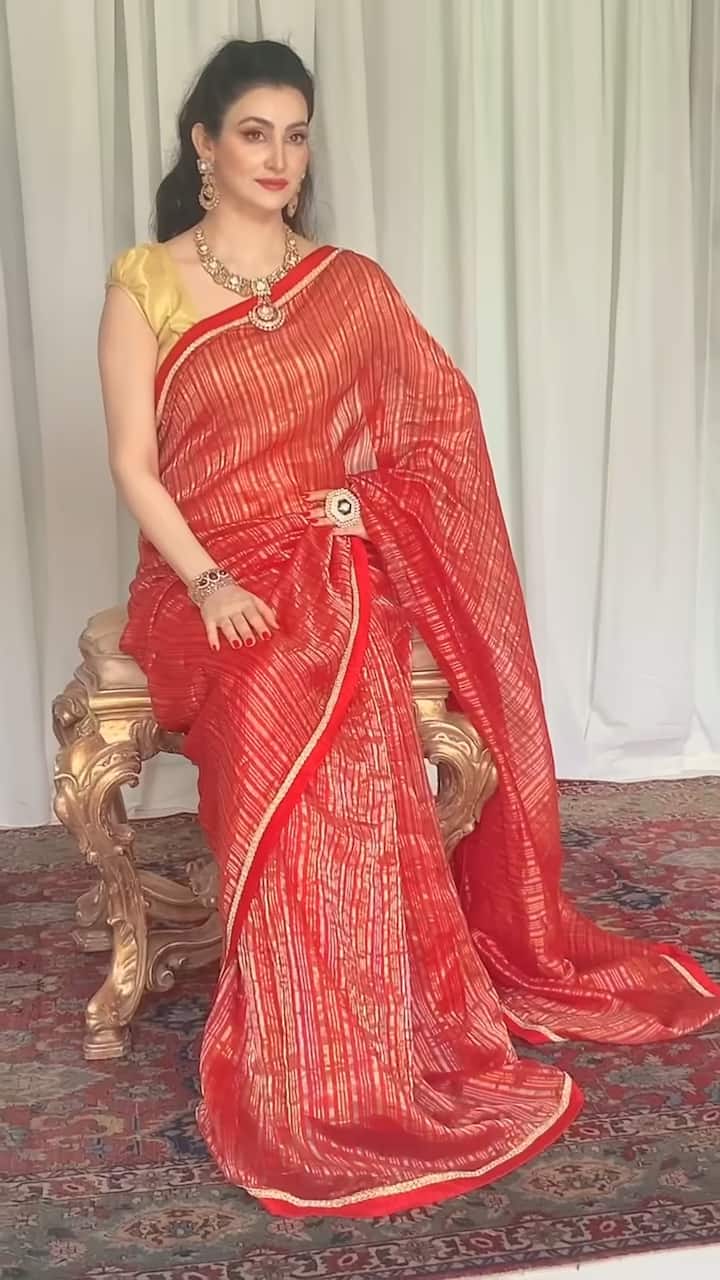 Next up is Shalini Passi's stunning red saree paired with a golden blouse. The luxurious silk saree features a subtle gold sheen, creating a timeless and elegant combination that never fails to impress.