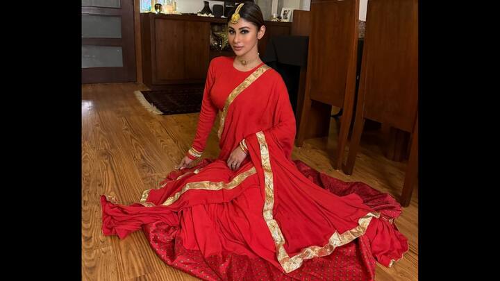 1. Mouni Roy: Mouni’s red attire is an epitome of elegance. This outfit features a bright red fabric and gold border for a classic and powerful look. Paired with a matching lehenga, it’s timeless and perfect for celebrations. (Image Source: Instagram/@imouniroy)