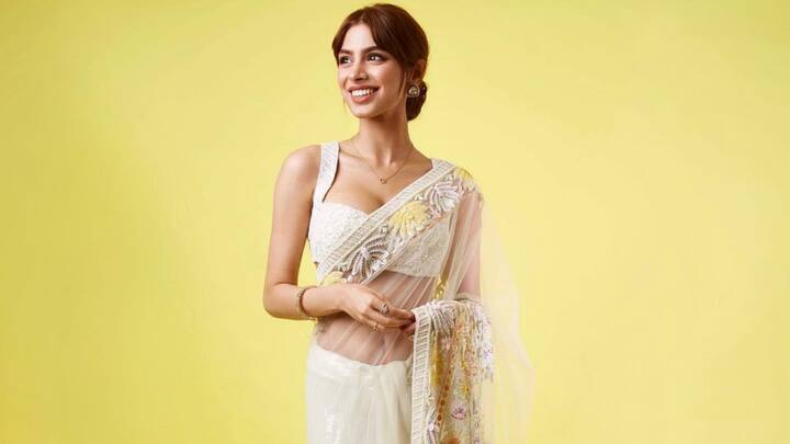 Her white net saree with delicate floral embroidery highlights her figure gracefully. She completes the ensemble with golden jewellery and a golden-green bangle, finishing with a dazzling embellished clutch that adds a touch of glamour. (Image source: Instagram/ khushikapoor)