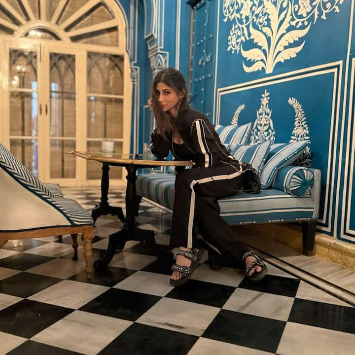 In another shot, Mouni relaxed on a colorful patchwork swing, sporting a crisp white shirt and black trousers, effortlessly embodying both elegance and ease.