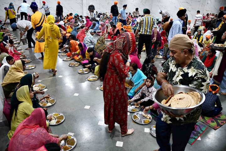 Sikhs devotees prepare roti food for Langar on the occasion of of Guru Nanak Jayanti the birth anniversary of the first Sikh Guru at Guru dwara, in Prayagraj on Friday, November 15, 2024. (PTI Photo)