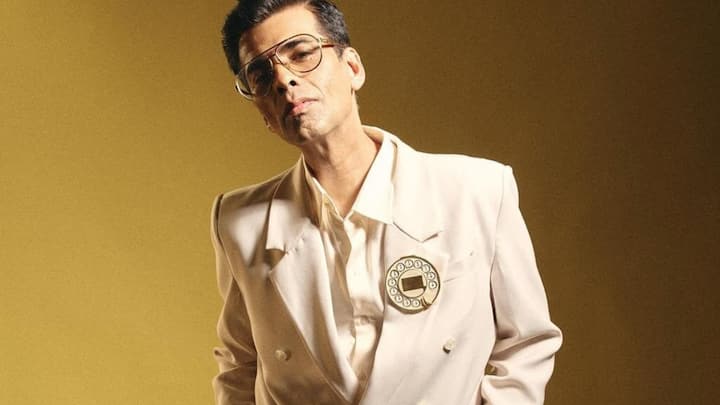 Karan Johar recently attended an event in Mumbai wearing an ivory suit with a luxury Telephone Dial brooch.