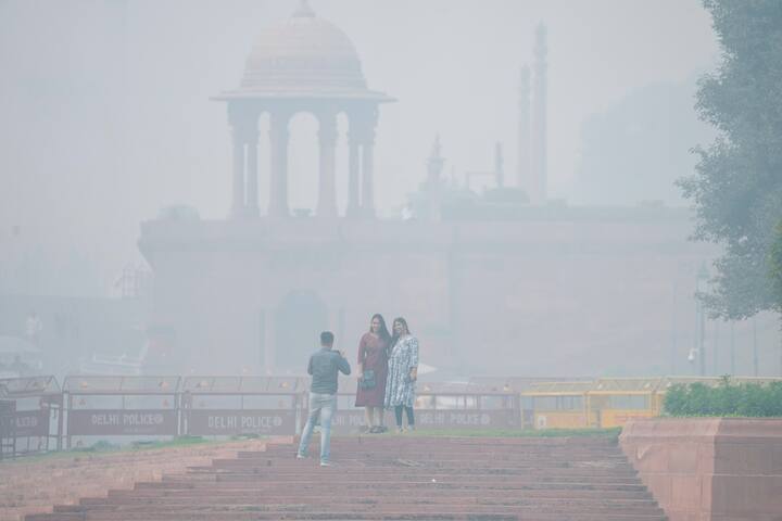 Visitors take pictures near the Vijay Chowk during smog, in New Delhi, Sunday, Nov. 17, 2024. (Source: PTI)