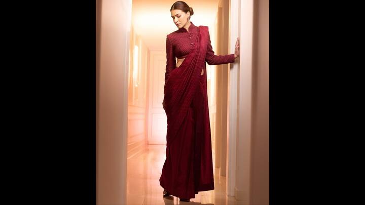 4. Kriti Sanon: Kriti looked sophisticated in a maroon saree paired with a high-collar cropped shirt blouse. Her minimalist approach to accessories and her bun made it a standout contemporary choice for a wedding ceremony or a cocktail party. (Image Source: Instagram/@kritisanon)