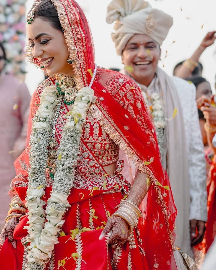 His bride was looking very lovely in a scarlet red dress.