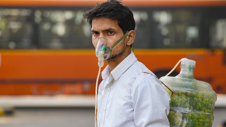 A protester wears an oxygen mask during a protest against air pollution, near the Parliament House complex, in New Delhi on Wednesday.  (Photo: PTI)