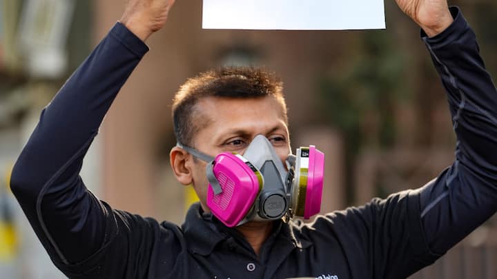 A protester wearing a gas mask holds a poster, near the Parliament House complex on Wednesday. The protesters gathered under a 