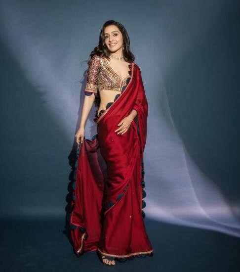 ફિલ્મ સ્ત્રી 2ના પ્રમોશન દરમિયાન શ્રદ્ધા કપૂર આ સાડી પહેરેલી જોવા મળી હતી. શ્રદ્ધાએ આ લાલ સાડી સાથે બ્લૂ, રેડ અને ગોલ્ડન બોર્ડર સાથે એમ્બ્રોઇડરી કરેલું બ્લાઉઝ પહેર્યું છે. તેના લુકને પૂર્ણ કરવા માટે શ્રદ્ધાએ પાતળો નેકલેસ, ઇયરિંગ્સ અને વીંટી પહેરી છે. શ્રદ્ધાએ મેકઅપને હળવો અને ચમકદાર રાખ્યો છે.