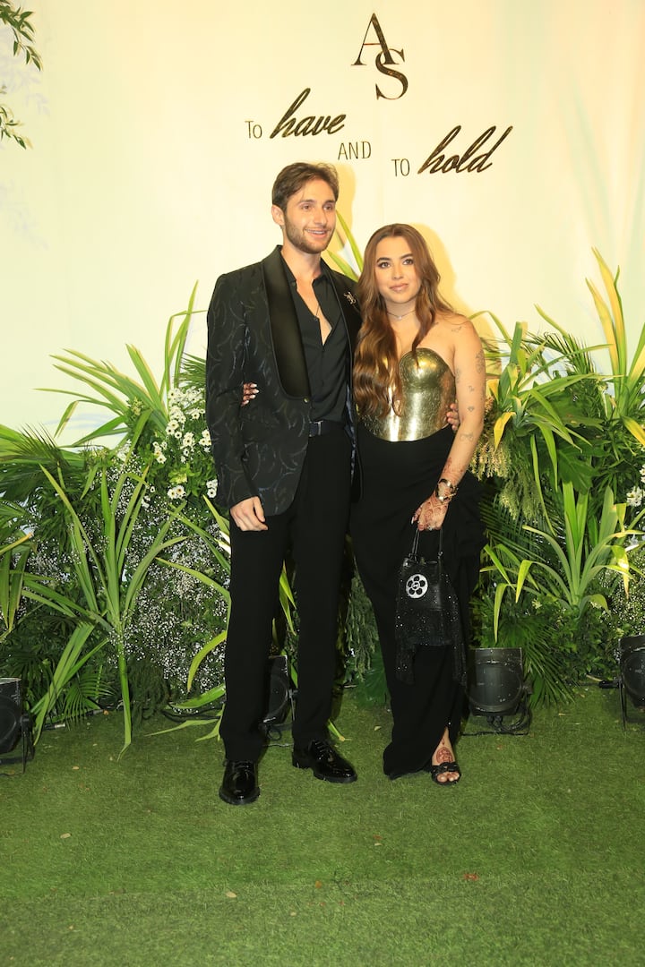 वेडिंग रिसेप्शन के लिए आलिया ने गोल्ड प्लेटेड टॉप के साथ ब्लैक स्कर्ट पहनी. इस लुक में वे एक मॉडर्न ब्राइड लग रही थीं. वहीं ब्लैक कोट-पैंट में शेन भी काफी अच्छे लग रहे थे.