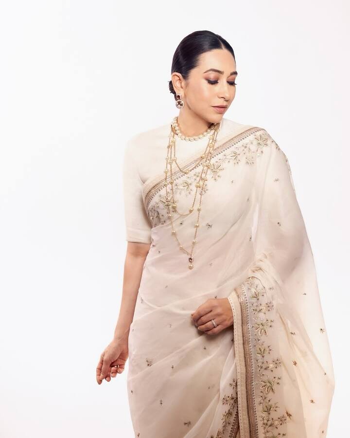 Karisma's dew makeup, with a sleek hari bun and a minimal statement jewellery look was a complete package for her saree look.