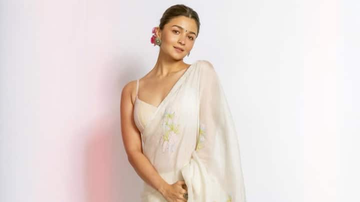 She stunned in an ivory saree with a soft, embroidered border. Accessories were restricted to that single silky red rose in her hair that just added to the timeless elegance she carries, presenting herself in the purest manner with serene yet powerful beauty. (Image source: Instagram/ aliaabhatt)