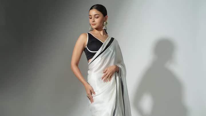 With a bold fashion statement, Alia did traditional-from a simple white saree by having a black blouse with it and bold earrings. The blending of traditional and modern elements gave her an all-new contemporary and bright fresh wear for events. (Image source: Instagram/ aliaabhatt)