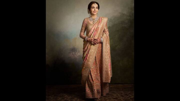 5. Pastel Elegance: Nita Ambani's pastel saree with gold accents gives her a regal look. The delicate gold accents enhances the richness of the saree. She has paired her loo with sparkling statement jewellery. (Image Source: Instagram/@weddingsutra)