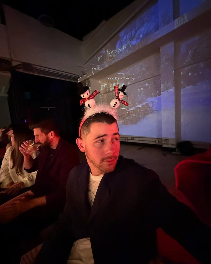 The couple celebrated with friends, sitting at a beautifully decorated table with red candles and floral arrangements.
