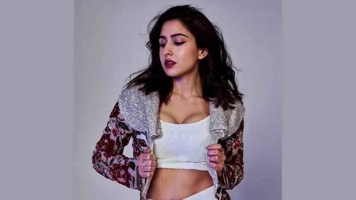 Sara Ali Khan dazzled in a glimmering white co-ord set comprising a U-neck cropped top, sequined flared trousers, and a long matching jacket. Her sparkly costume made heads turn along with neighboring onlookers, glamorising any festive wardrobe. (Image source: Instagram/ saraalikhan)