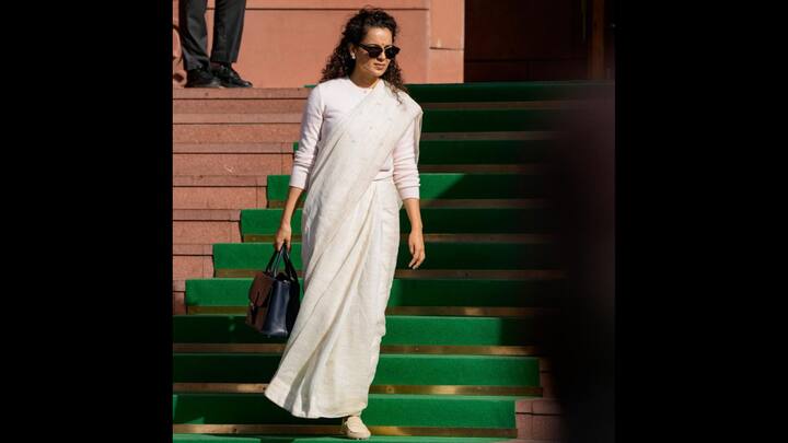 5. White Monochromatic Look: Kangana opts for a white monochromatic look at a parliament session, pairing a white saree with a matching sweater for a simple, elegant vibe. A bold blue handbag adds a striking pop of colour to her outfit. (Image Source: PTI)