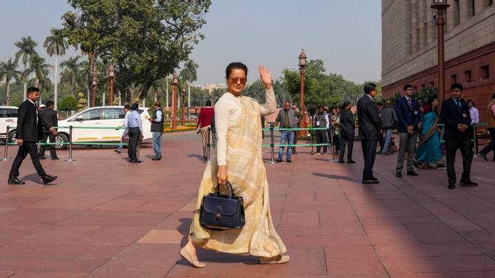 4. Saree With White Sweater: Kangana effortlessly aces her winter saree looks, pairing a pure white sweater with a simple saree. The saree features yellow, brown, and white colours which go perfectly well with her sweater. Her blue stunning handbag adds a touch of elegance and elevates the look. (Image Source: PTI)