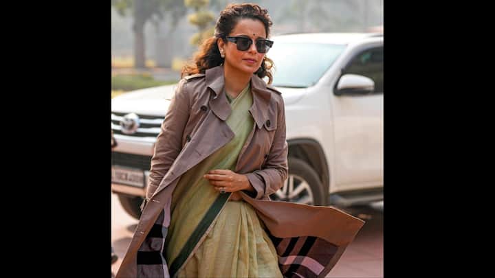 7. Green Saree With Brown Trench Coat: Kangana Ranaut pairs a simple green saree which has darker green borders with a brown trench coat. Her outfit gives her an elegant vibe. She has accessorised her look with pearl earrings, a green emerald ring, and bold black sunglasses. (Image Source: PTI)
