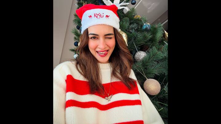 1. Kriti Sanon: Kriti Sanon embraces the festive spirit in a cosy style. She has adorned a cosy oversized sweater with red and white stripes and a customised Christmas cap with her name on it. The actress playfully poses infront of her beautifully decorated Christmas tree. (Image Source: Instagram/@kritisanon)