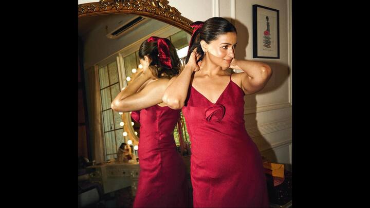 2. Alia Bhatt: Alia Bhatt looks effortlessly flawless in her chic satin red dress that beautifully captures the festive Christmas spirit. She paired her look with a velvet hair bow and a detachable rose brooch. Alia's outfit radiates perfection and grace. (Image Source: Instagram/@aliaabhatt)