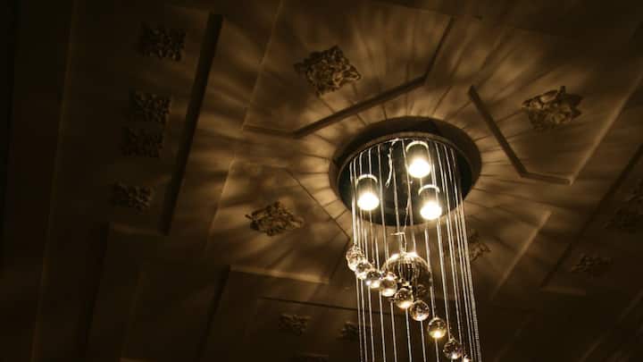 2. Statement Ceilings and Lighting: ​​For years, ceilings were the silent observers of our interiors, painted in predictable white and left untouched. Then came a design revolution. Ceilings transformed into bold canvases, with homeowners embracing everything from detailed panelling to striking wallpaper. This shift coincided with the softening of interior lighting. The harsh overhead fixtures of the past gave way to Noguchi-style pendants, elegant wall sconces, and concealed LED accents. These lighting choices not only illuminated spaces but became integral design features. (Image Source: Canva)
