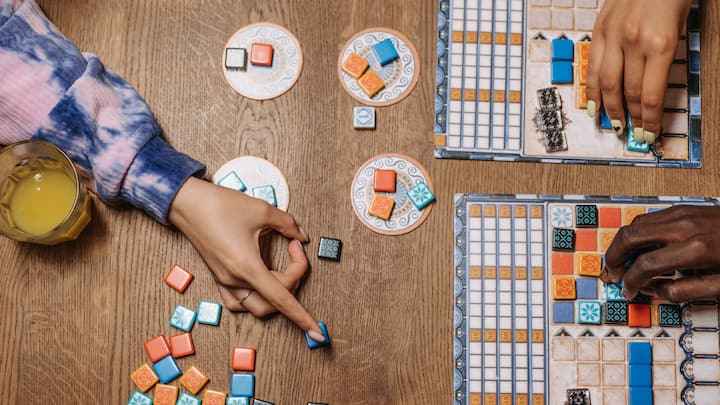6. Games Night Marathon: A game night marathon is the perfect celebration for New Year's Eve. You can enjoy a variety of board games or indoor games, and even split into teams for extra fun and competition. It will definitely keep everyone engaged and entertained, making it a memorable New Year's Eve celebration. (Image Source: Canva)