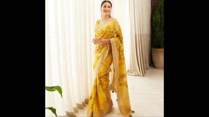 5. Madhuri Dixit: Madhuri Dixit dazzles in a gorgeous yellow saree that has beautiful floral prints. The saree has intricate detailing around the borders that adds a graceful touch. The actress has completed her look with bold earrings and a stunning golden bangle. (Image Source: Instagram/@madhuridixitnene)