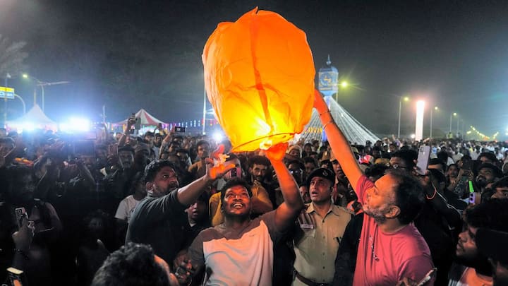 People across the country welcomed New Year 2025 with great enthusiasm and celebrations. In Chennai, people ringed in the new year by releasing a lantern at Marina Beach. Image: PTI