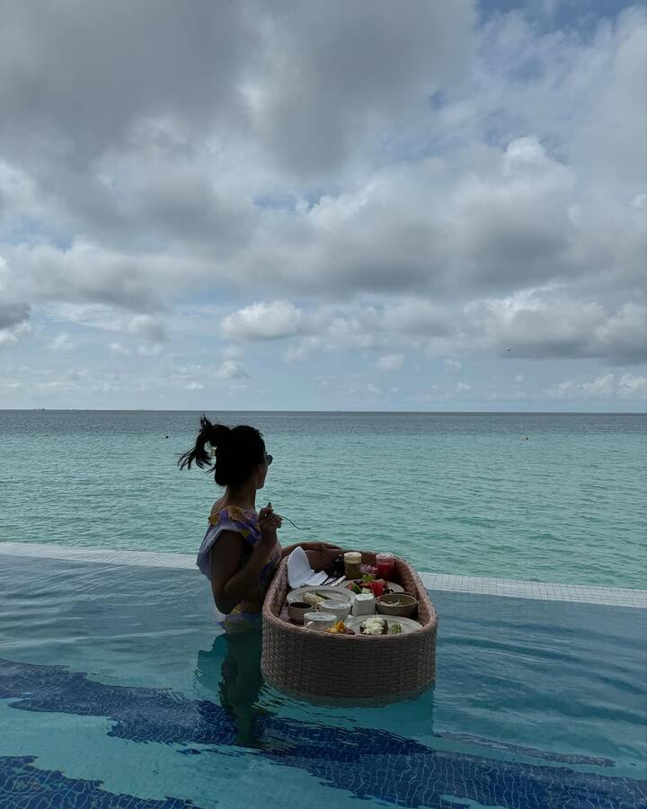 To complete her effortlessly fashionable beach ensemble, Surbhi styled her hair in a messy bun.