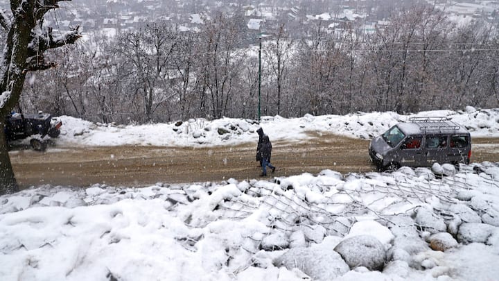 A person walks amid fresh snowfall at Tangmarg area, in Baramulla district, Jammu and Kashmir. The mercury has stayed below two degrees Celsius for the past 48 hours as the maximum temperature on Saturday was 1.2 degrees Celsius.  (Photo:PTI)