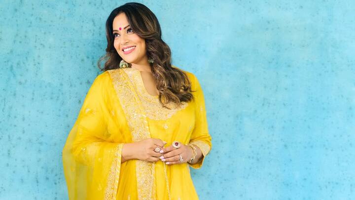 Wearing a bright yellow sharara set, Bipasha lit up the space. The kurta flaunts three-fourth sleeves and a plunging neckline, all complemented by intricate zari and gota-patti detailing. With a crinkled sharara and a matching dupatta, you can go for this cheerful and elegant look for any celebration. (Image Source: Instagram/ bipashabasu)