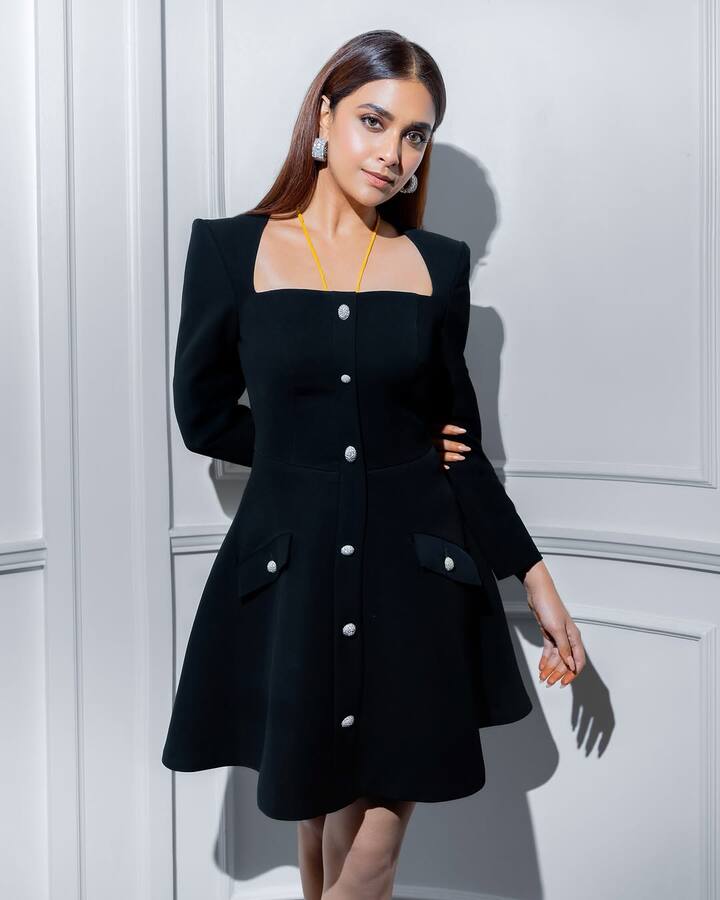 బ్లాక్ కలర్ లాంగ్ స్లీవ్ మినీ డ్రెస్ వేసుకుని ఫోటోలకు స్టన్నింగ్ ఫోజులిచ్చింది కీర్తి. Lili Blanc'S Iconic Collar And Crystal Buttonsతో వచ్చిన ఈ డ్రెస్ 36 వేలకు పైమాటే.  (Image Source : Instagram/Keerthy Suresh)