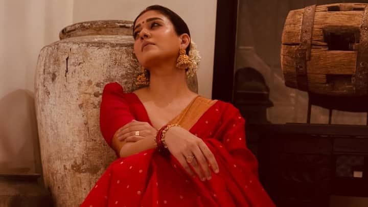 Nayanthara displayed heritage style in a red saree with coordinating gold toning borders and a minimalist golden accent on the pallu. She went minimalist accessorised with standout jhumkas, a gajra-adorned bun, and kohl-rimmed eyes. (Image source: Instagram/ nayanthara)