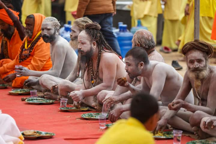 Sadhus of Shambhu Panchayti Atal Akhara sit for a meal during a 'Peshwai', or royal entry procession, ahead of the Mahakumbh, in Prayagraj, Wednesday, Jan. 1, 2025. (Image Source: PTI)