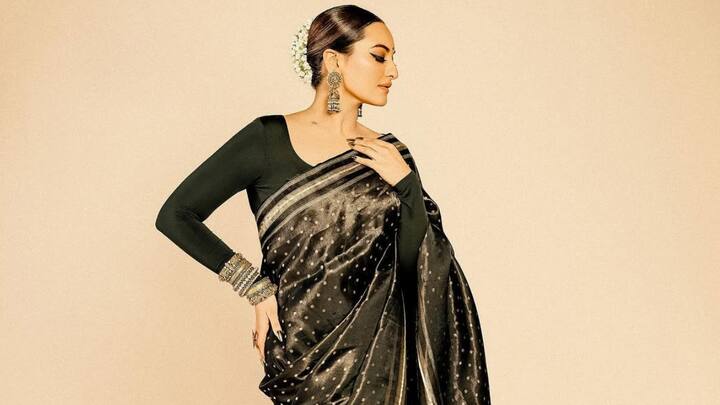 Sonakshi Sinha stuns in the black and golden saree, paired with heavy golden jewellery and dramatic makeup. Her sleek bun adorned with jasmine flowers is a traditional touch that makes her look like an epitome of elegance and sophistication. (Image Source: Instagram/ aslisona)