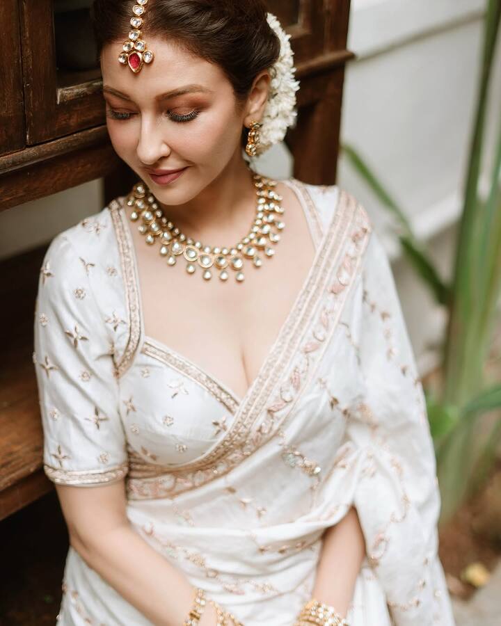 Her jewelry was elegant, with traditional gold earrings, a delicate bracelet, and a ring that beautifully matched the gold embroidery of the saree.