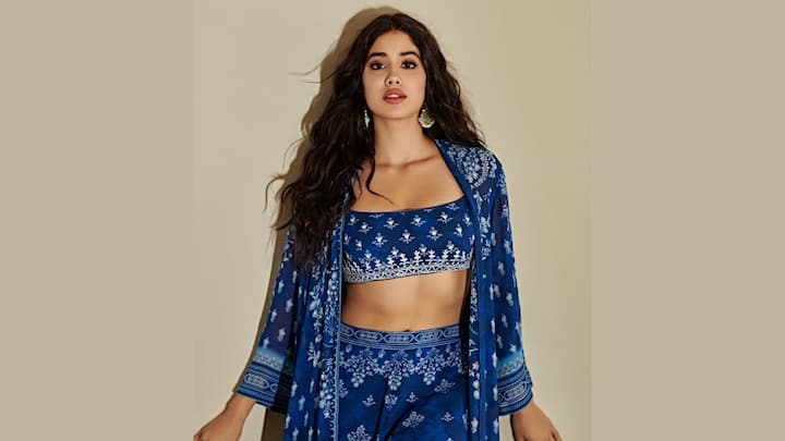 Janhvi Kapoor gives a cool-chic look in her printed indigo co-ord set that includes a crop top and high-waisted trousers, flowing chiffon cape, and looks fabulous with bohemian-style chunky silver earrings.  (Image Source: Instagram/ janhvikapoor)