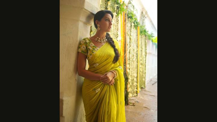 5. Traditional Yellow Attire: Nora Fatehi looked radiant in a yellow saree adorned with white beaded floral embellishments. The actress paired her look with a matching blouse that enhanced her look. She complemented her traditional attire with heavy jewellery that added a regal touch. (Image Source: Instagram/@norafatehi)