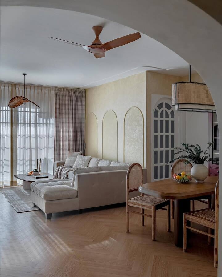 The dining area has a rattan chandelier, a wooden dining table with cane chairs, and a bold red crockery cabinet.