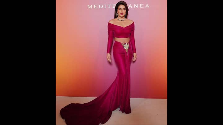 1. Magenta Bodycon Co-ord Set: Priyanka Chopra made a striking statement in a vibrant magenta co-ord set. Her outfit featured a cropped top with ruched detailing and dramatic off shoulder sleeves that added elegance to her look. She wore a long fitted skirt that cascaded into a flowing train. The actress elevated her look with a delicate floral brooch at the waist give her a chic touch. (Image Source: Instagram/@priyankachopra)