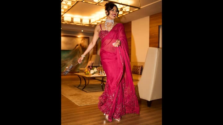 6. Embellished Saree: Priyanka stunned in a deep red saree. She wore a heavily embellished blouse that added a modern twist to the traditional attire. The actress completed her look with statement pearl jewellery and a bold red lip colour. (Image Source: Instagram/@priyankachopra)