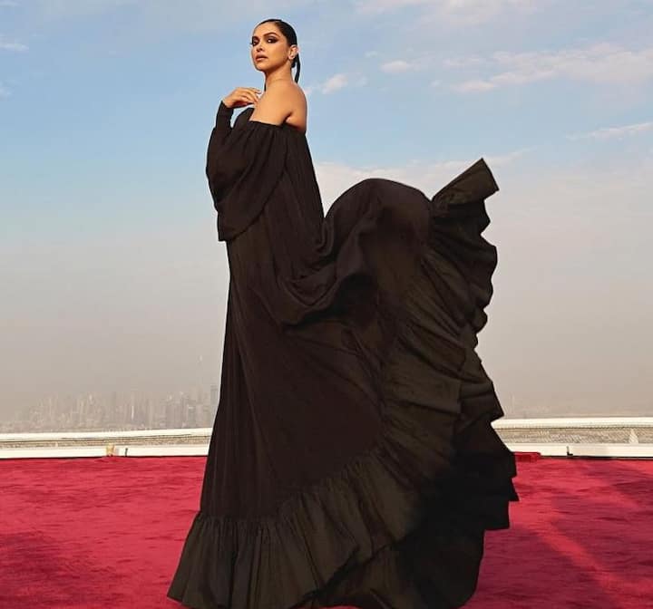 The ensemble boasts a dramatic sweetheart neckline and an off-the-shoulder silhouette with voluminous sleeves.