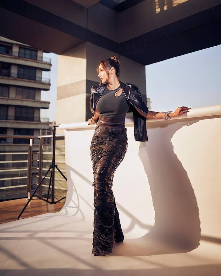 The fitted silhouette of the tank top highlighted her figure, making it an elegant yet casual choice. Pairing the top with a black skirt that featured shiny metallic designs elevated the look, injecting a sense of glamour