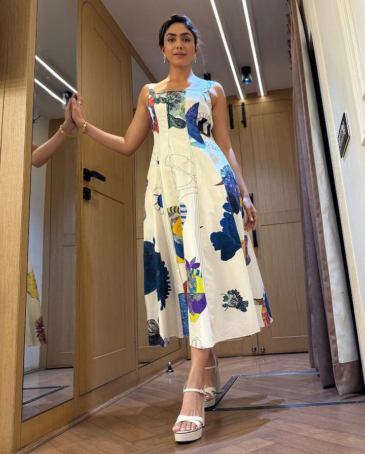 Mrunal wore a white cotton midi dress with bright blooms printed all over, designed by SAAKSHA & KINNI.