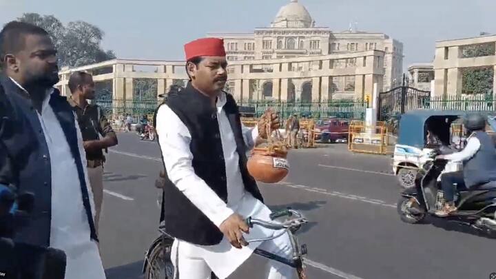 सपा नेता साइकिल से विधानसभा पहुंचे, उन्होंने हाथ में अस्थि कलश ले रखा था. उनके विरोध प्रदर्शन का तरीका चर्चा का विषय बना हुआ है.