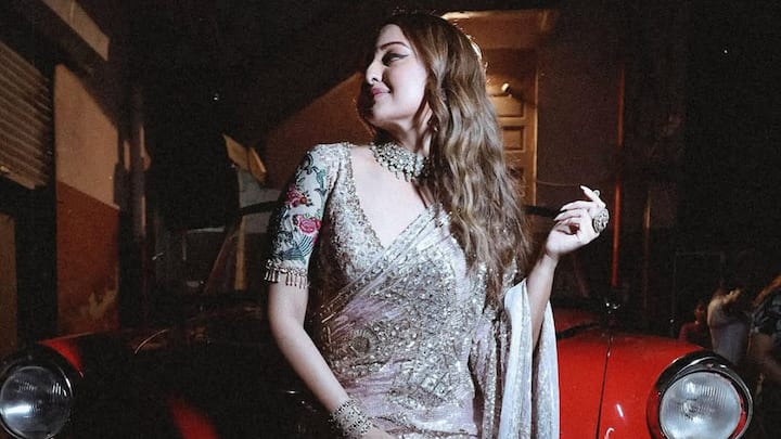 This pink saree with silver sequins and gold embellishments made Sonakshi looked radiant. Loose wavy hair, a bold choker, and eye makeup complemented her redefined yet striking appearance. (Image Source: Instagram/ aslisona)