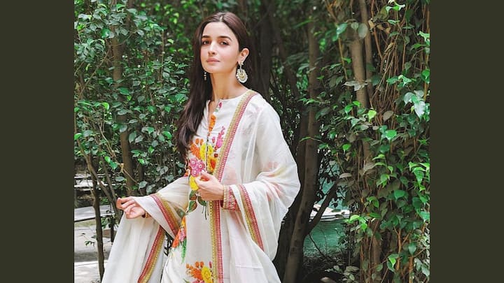 Alia Bhatt looks magnificently casual in a white cotton sharara set full of colourful floral prints. The outfit is complemented by a cotton dupatta with pink and gold borders, refreshing yet elegant enough for a puja or any daytime festive occasion. (Image Source: Instagram/ aliaabhatt)